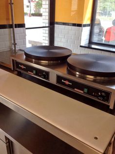 two pans sitting on top of a stove in a kitchen next to a window