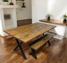 a wooden table with two benches in front of it on top of a hard wood floor