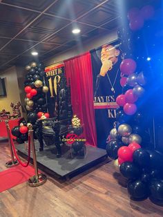 an event with balloons and black and red decorations