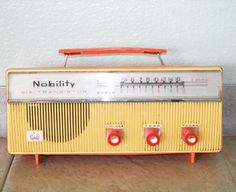 an old yellow radio sitting on the floor