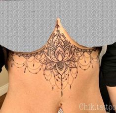 the back of a woman's body with tattoos on her stomach and an intricate design