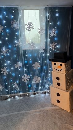 two boxes stacked on top of each other in front of a window with snowflakes