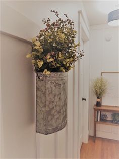 a planter hanging on the wall with flowers in it