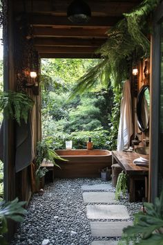 an outdoor bathroom with stone flooring and plants on the walls, along with a bathtub