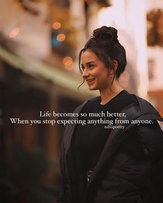 a woman standing in front of a building with a quote about life becomes so much better, when you stop expecting anything from anyone