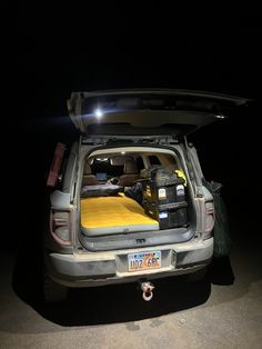 the back end of a car with its trunk open and luggage in it's trunk