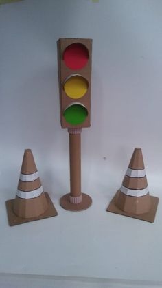 three traffic lights with cones around them on a table