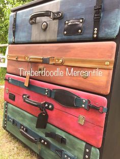 a stack of suitcases sitting on top of each other in front of some trees