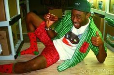 a man sitting on the floor wearing red and green socks