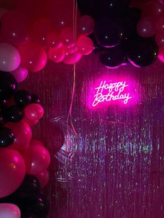 balloons and streamers in the background with a happy birthday neon sign on it's wall