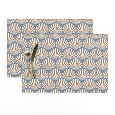 a pair of scissors sitting on top of a blue and white place mat with an art deco design