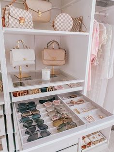 a white closet filled with lots of purses and handbags next to each other