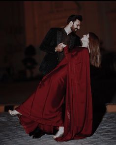 a man and woman dressed in red dancing