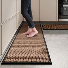 a woman standing on the kitchen floor with her feet in the oven doormats