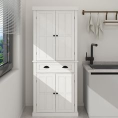 a white cabinet next to a sink in a room