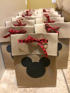 some brown bags with red bows and mickey mouse ears on them