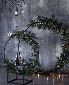 a christmas wreath with lights on it next to a table