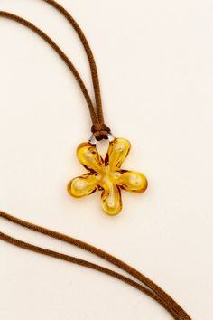 a brown cord with a yellow flower pendant on it's end and a string attached to it