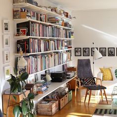 a living room filled with lots of furniture and bookshelves full of books on shelves