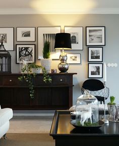 a living room filled with furniture and pictures on the wall above it's coffee table