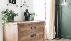 a wooden dresser sitting next to a window