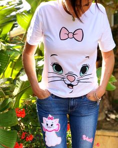 a woman wearing jeans and a t - shirt with an image of a cat on it