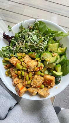 a white bowl filled with vegetables and meat