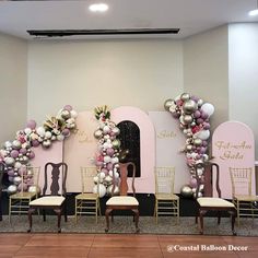 several chairs are lined up in front of a wall decorated with balloons and other decorations