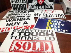 four signs are on the table in front of each other, and one is for real estate