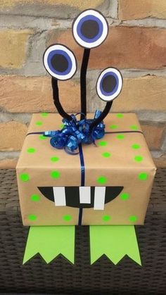 a cardboard box with two fake eyes on it and a ribbon tied around the top