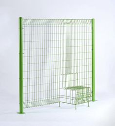 a green wire fence with two chairs in it