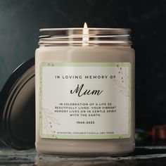 a candle is sitting on a table with the words in loving memory of mum printed on it