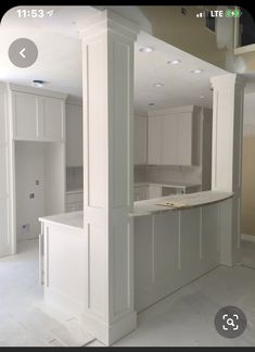 an empty kitchen is shown with white cabinets and counter tops in the middle of the room