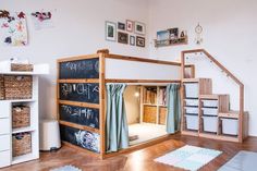 there is a bunk bed in the room with chalkboard on the wall and shelves below it