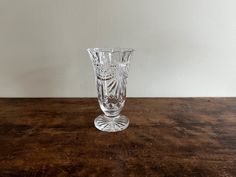 a clear glass vase sitting on top of a wooden table