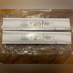 two harry potter wands are wrapped in plastic