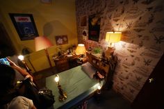 a person taking a photo of a bed in a room with wallpaper and lamps