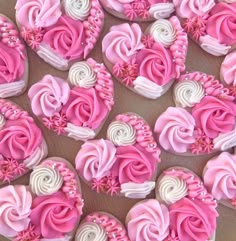 pink and white cupcakes are arranged in the shape of hearts