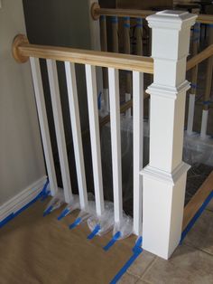 the stair railing is being painted white with blue tape