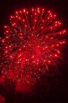 a red fireworks is lit up in the night sky