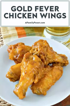 a white plate topped with chicken wings covered in gravy