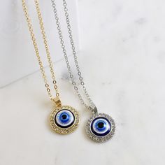 LARGE EVIL EYE ROUND PENDANT NECKLACE Evil eye necklace with large pendant, available in silver and gold. Evil Eye - 2cm Evil Eye - Acrylic Cubic Zirconia Length 50cm + 4.5cm Extender Zinc Alloy Customer satisfaction is very important to us and so is your feedback. If you are happy with our service and purchase please leave 5 stars.  If for any reason you are not happy with service or products please don't hesitate to contact us with any concerns, prior to leaving your review. All dimensions are Metal Evil Eye Necklace With Round Shape, Evil Eye Metal Necklace With Round Shape, Evil Eye Round Metal Necklace, Silver Pendant Necklace With Diamond Eyes, Silver Evil Eye Round Pendant Necklace, Silver Necklace With Evil Eye Round Pendant, Spiritual Metal Evil Eye Necklace, Spiritual Evil Eye Metal Necklace, Eye Round