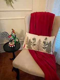 a chair with a christmas decoration on it next to a small table