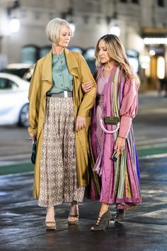 two women standing next to each other on a street