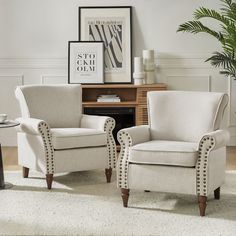 two white chairs sitting next to each other in a living room