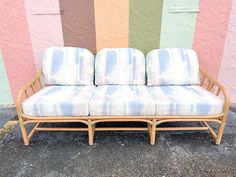 a couch sitting in front of a wall with colorful stripes on it's walls