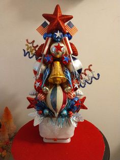 a patriotic christmas tree with red, white and blue decorations on it's base