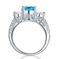 a blue topaz ring with diamonds on the sides and an oval center stone in the middle