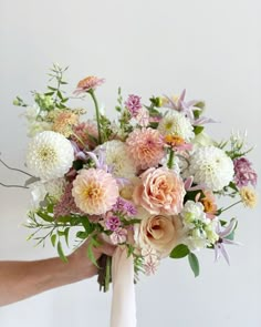 a person holding a bouquet of flowers in their hand