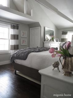 a bedroom with a bed, dresser and mirror in it's centerpieces